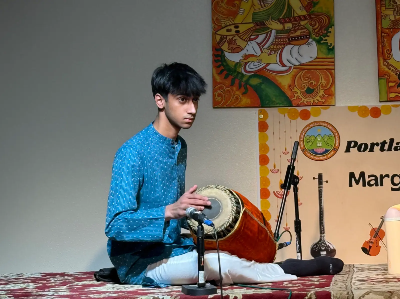Aditya Kumar playing the mridangam in a blue kurta